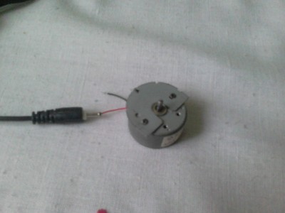 Motorek a nabíječka (zdroj). Červený drátek je uvnitř a na černý by měl přijít multimetr.